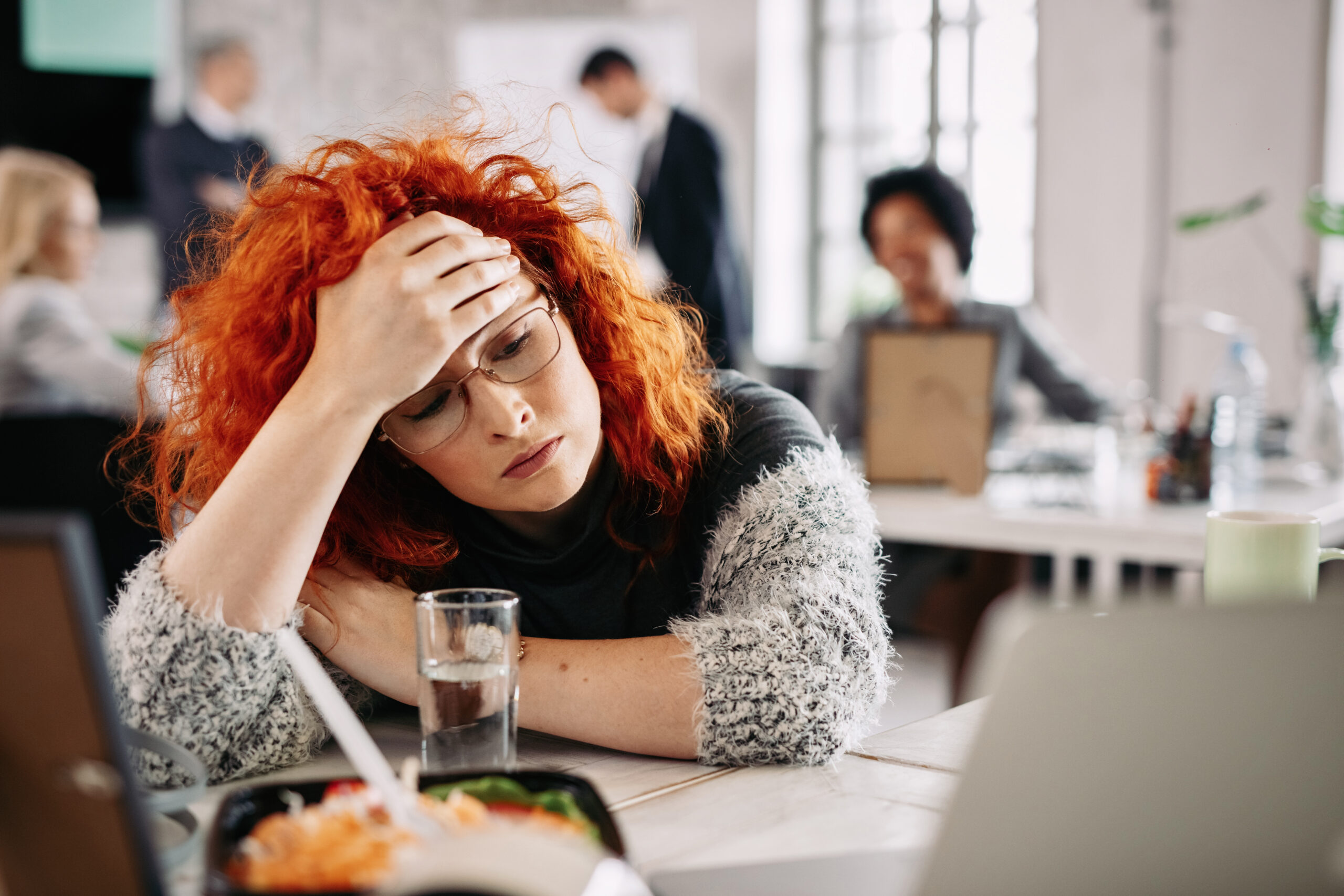 Pensive Redhead Entrepreneur Feeling Tired While Sitting Her Desk Office There Are People Background Scaled